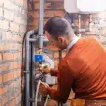 Technician checking valves and gauges on a boiler system