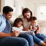 Family reading a book together on the couch in a comfortable home