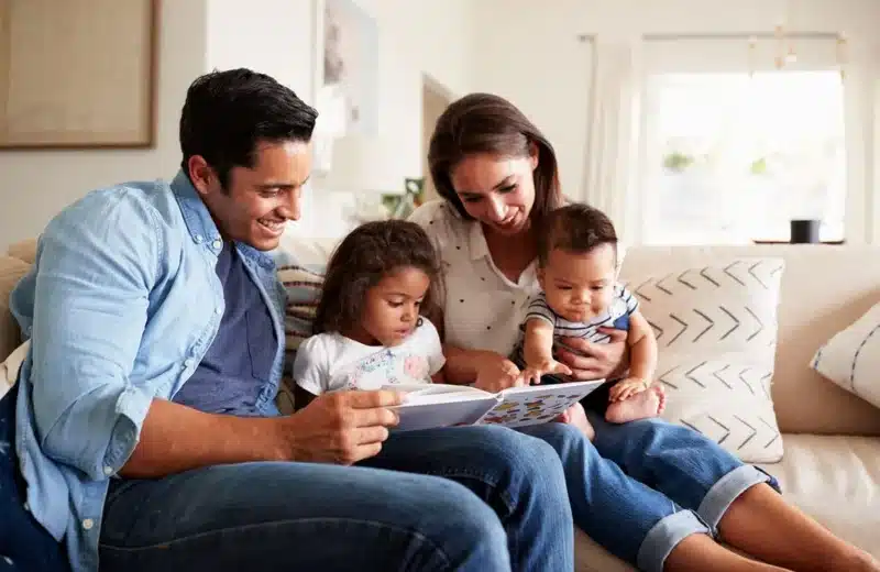 Family reading a book together on the couch in a comfortable home